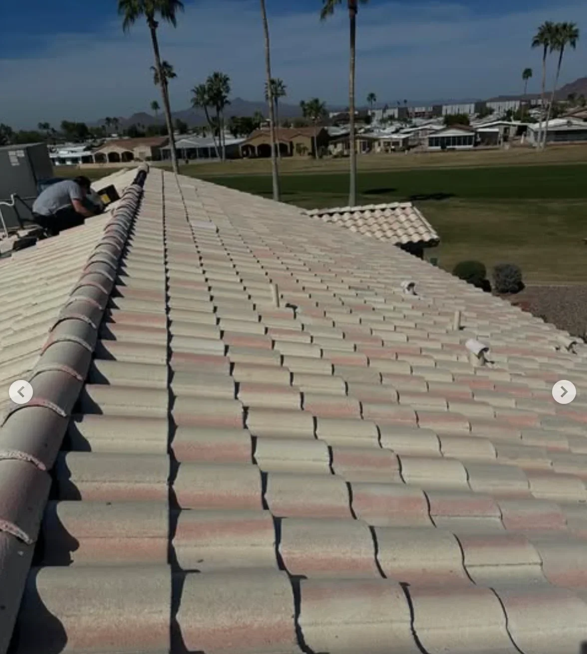 Clay tile roof installation with barrel tiles, underlayment, and ridge caps on commercial building